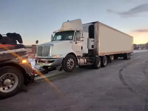 Heavy wrecker preparing to tow a commercial box truck