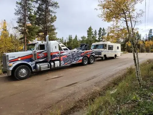 Heavy-duty wrecker transporting a large motorhome